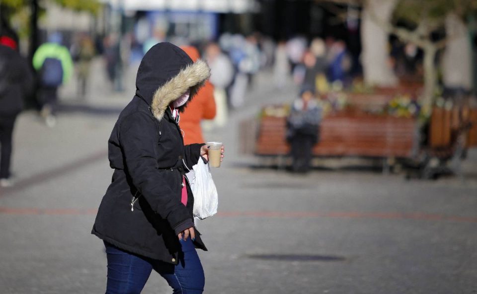 Foto mostra mulher com frio após declínio de temperatura no Paraná