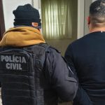 Foto mostra integrante de grupo chefiado por traficantes presos em presídio de Piraquara sendo preso pela Polícia Civil; ele está de costas.