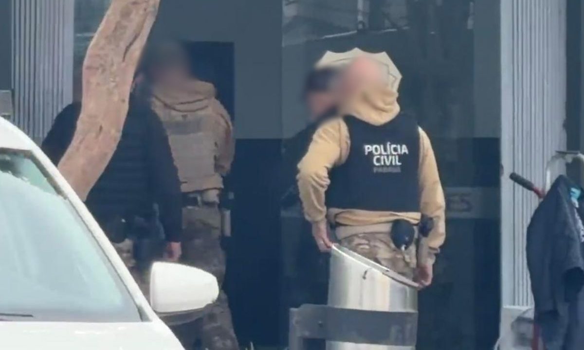 Policiais civis em frente à Central de Flagrantes de Curitiba durante atendimento de ocorrência envolvendo homem baleado após confusão em bar no bairro Hauer.