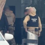 Policiais civis em frente à Central de Flagrantes de Curitiba durante atendimento de ocorrência envolvendo homem baleado após confusão em bar no bairro Hauer.