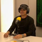 Marcão durante entrevista ao programa Balanço Esportivo, da Banda B, usando fones de ouvido e falando ao microfone no estúdio.
