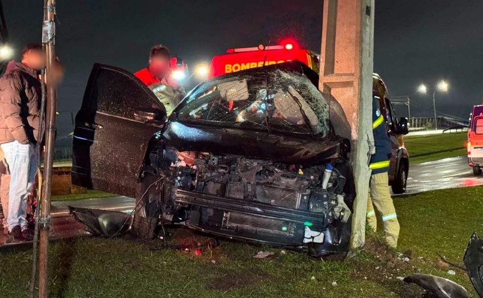Foto registrada à noite mostra bombeiros retirando motorista das ferragens após carro aquaplanar e bater contra poste em Curitiba