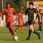 Atleta do FC Cascavel conduz a bola em partida da Série D enquanto é marcado por jogador adversário durante confronto da competição nacional.