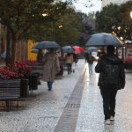 foto ilustrativa para a previsão do tempo em curitiba nesta sexta-feira. foto mostra uma pessoa agasalhada e segurando guarda-chuva