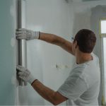 Programa Reforma Casa Brasil amplia limite de renda e facilita financiamento para reformas. A imagem mostra um homem reformando um ambiente.