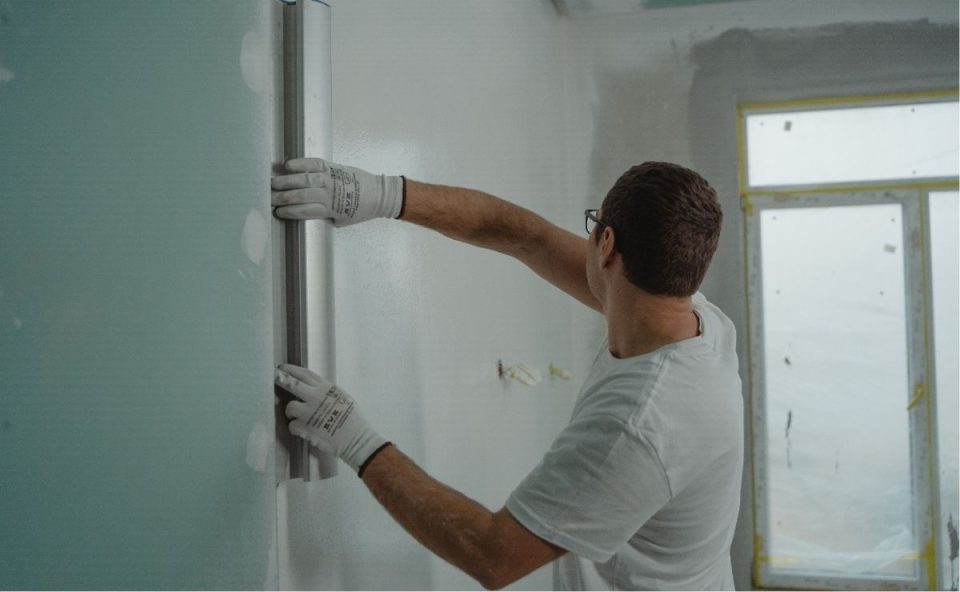 Programa Reforma Casa Brasil amplia limite de renda e facilita financiamento para reformas. A imagem mostra um homem reformando um ambiente.