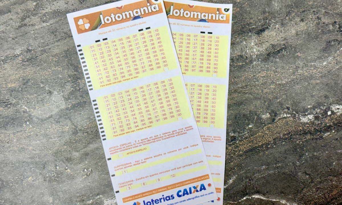 Volantes da Lotomania 2935 sobre mesa de mármore.