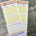 Volantes da Lotomania 2935 sobre mesa de mármore.