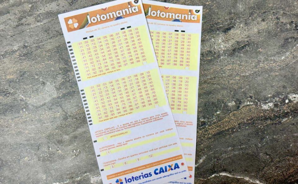 Volantes da Lotomania 2935 sobre mesa de mármore.