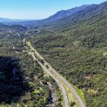 Imagem ilustrativa para o movimento nas rodovias do Paraná durante o feriado de Corpus Christi. Foto tirada de cima mostra uma rodovia em meio a area de vegetação.