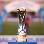 Troféu da Série D do Campeonato Brasileiro exposto no gramado de um estádio.